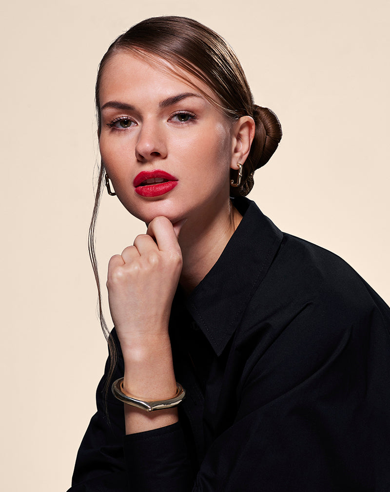 Model in black wearing a Heritage Cuff and Heritage Earrings