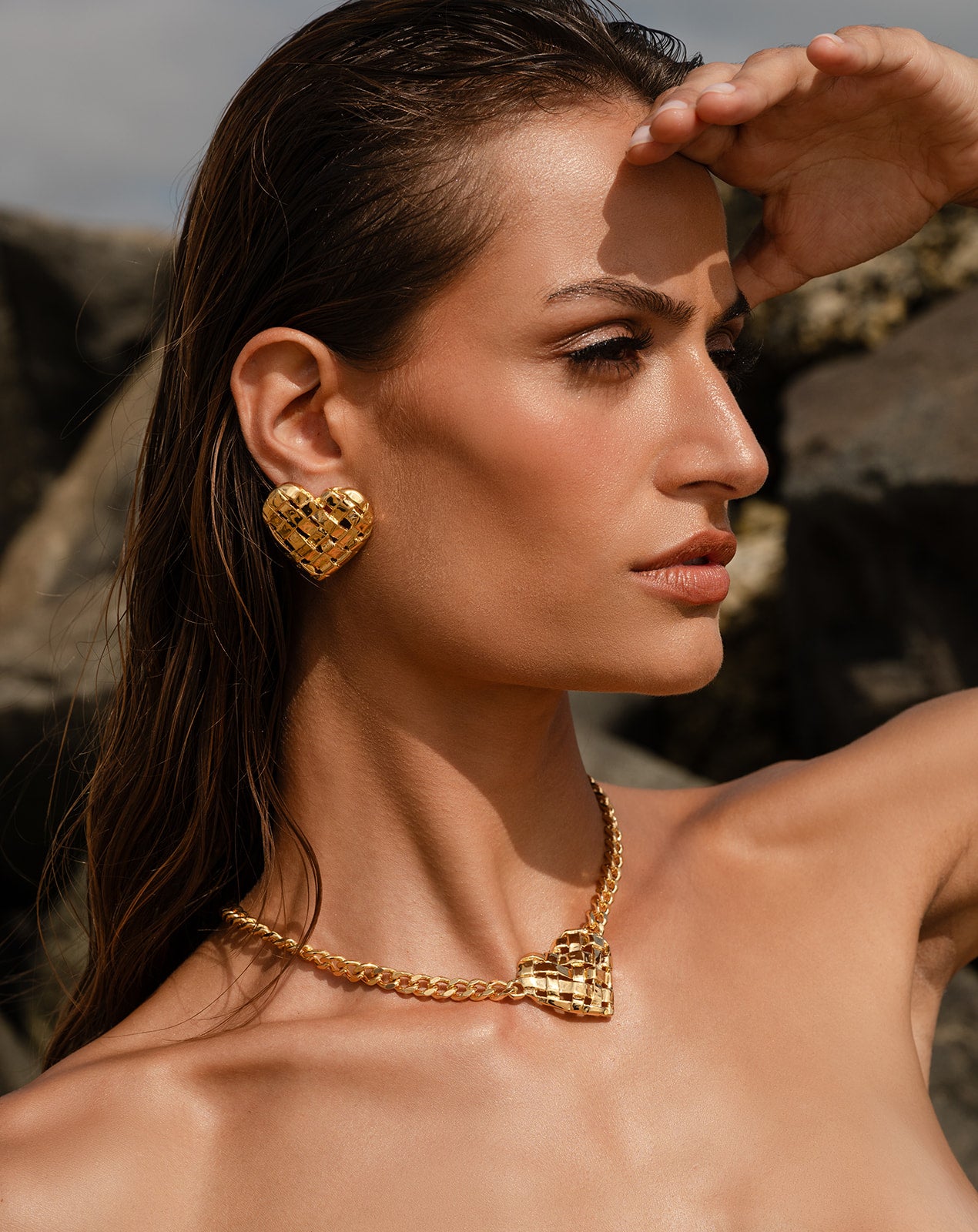 Model wearing Woven Heart Necklace with matching earrings, alternate angle.