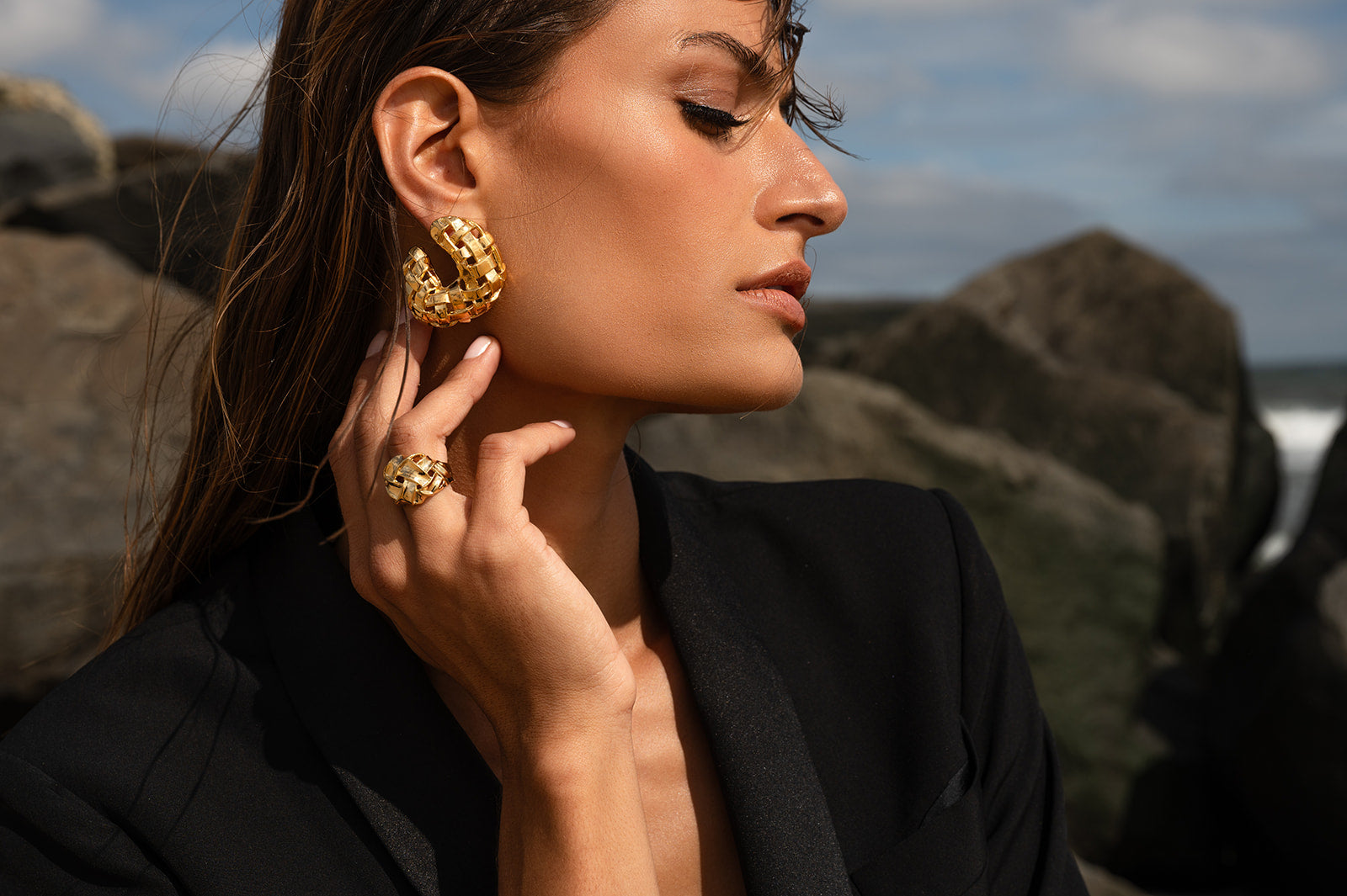 Model in black wearing Woven C Earring with matching ring