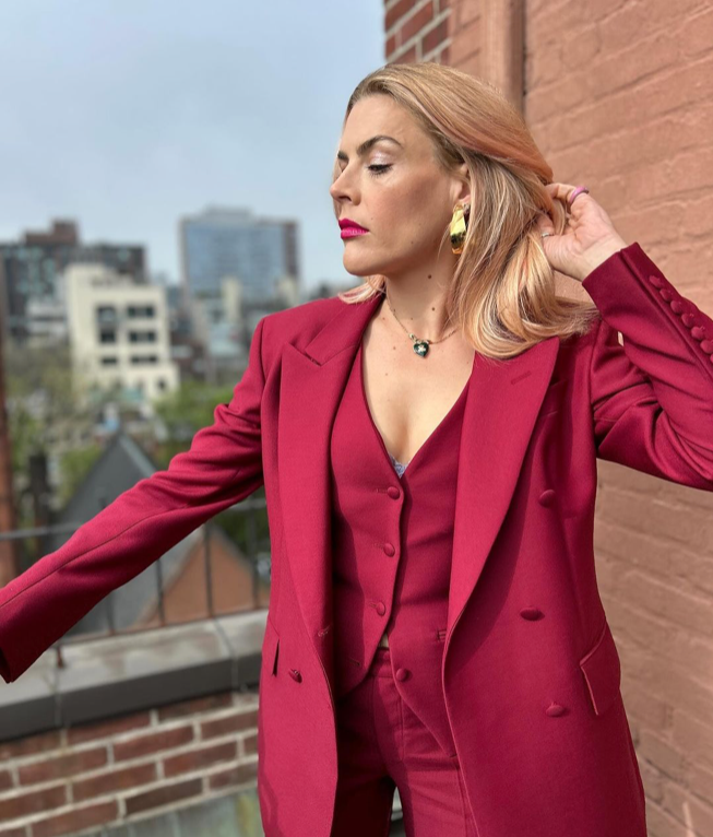 Woman in red suit wearing Petal Earrings