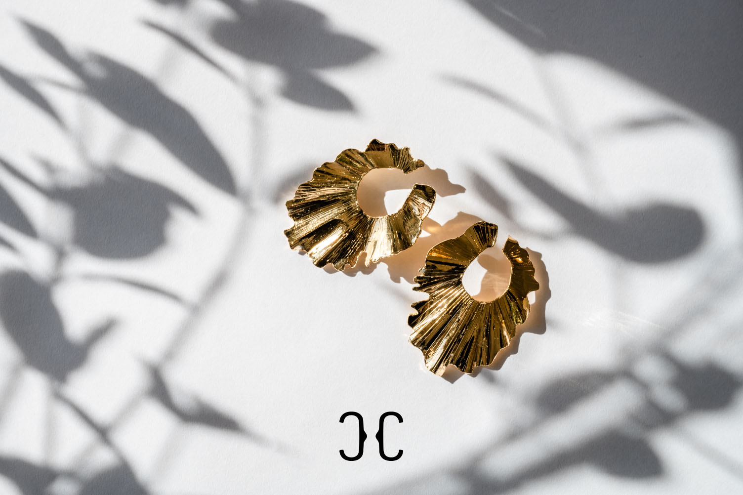 Christina Caruso earrings on display surrounded by shadowy light