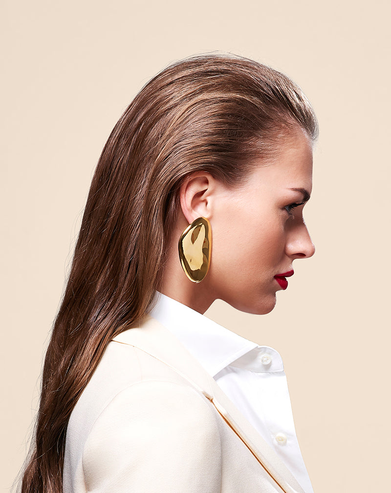 Profile shot of model in white wearing Oval Earrings in gold