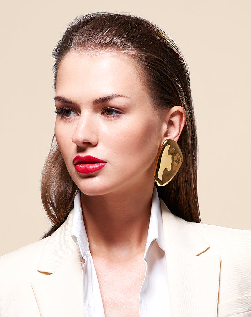 Alternate shot of Model in white wearing Oval Earrings in gold